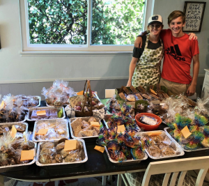 Michelle and Damon Holbrook standing by a table filled with bake sale treats at the largest bake sale to date, which raised $10,000 for the Choroideremia Research Foundation (CRF).