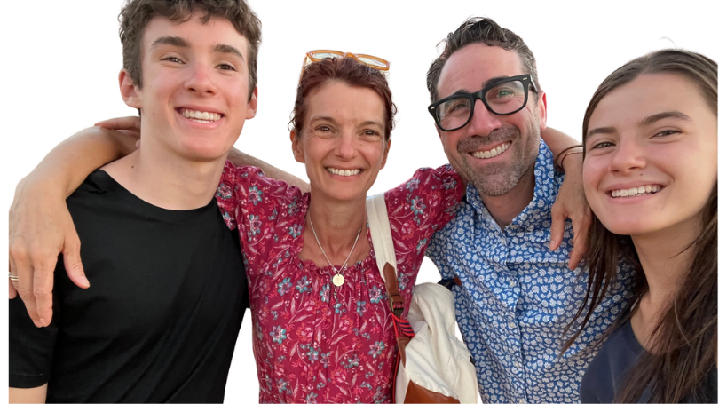 The Harp Family posing together in front of a light blue background.