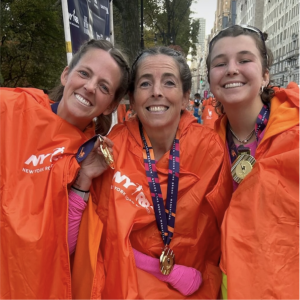 Team CHM runners Sarah Jensen and Naomi Brice posing with a family member after the marathon.